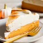 A slice of pumpkin pie on a plate with a fork.