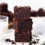 A stack of chocolate brownies on a plate.